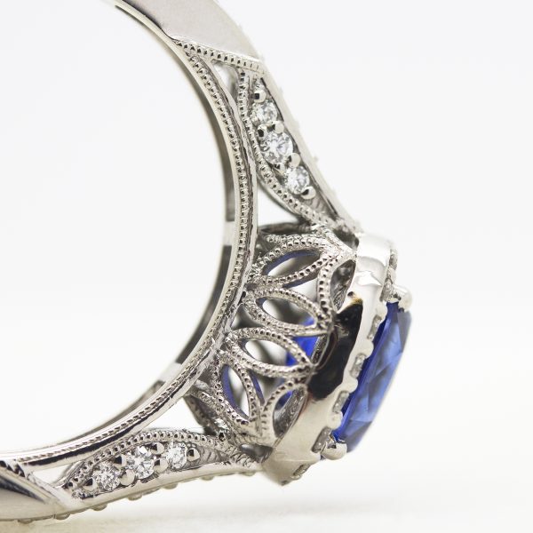 blue sapphire centre with diamond halo, filigree and milgrain detail engagement ring