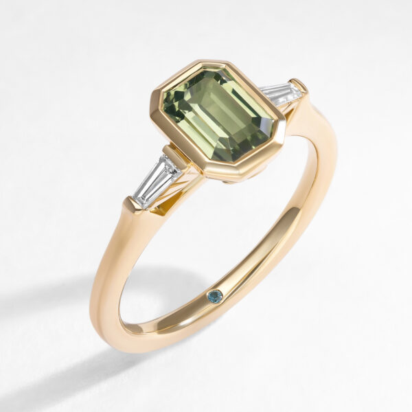 Art Deco inspired green emerald cut sapphire engagement ring with tapered diamond baguette side stones